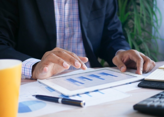 a person reviewing financial graphs on a tablet